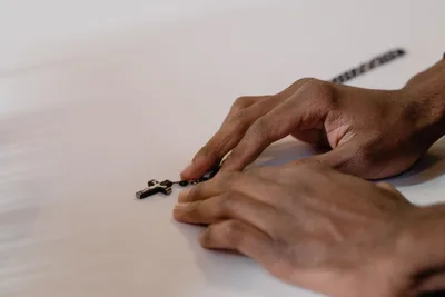 Manos en oración con un rosario